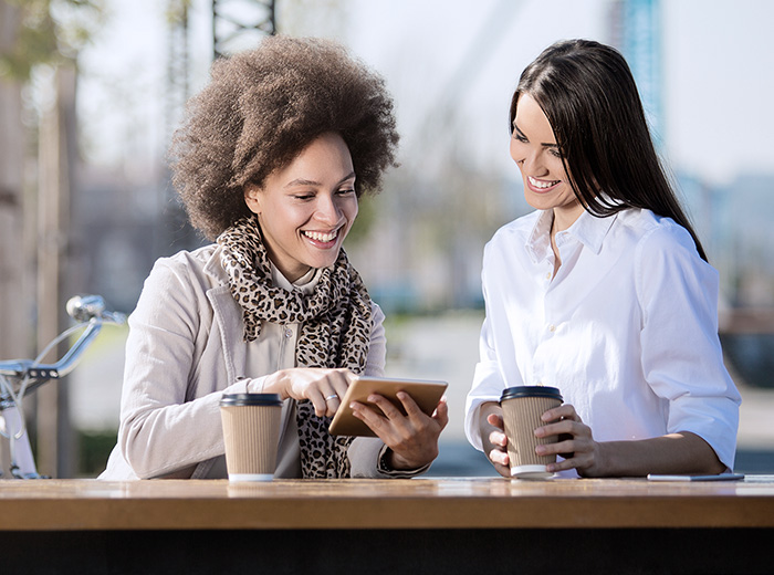 woman looking at tablet with coffee